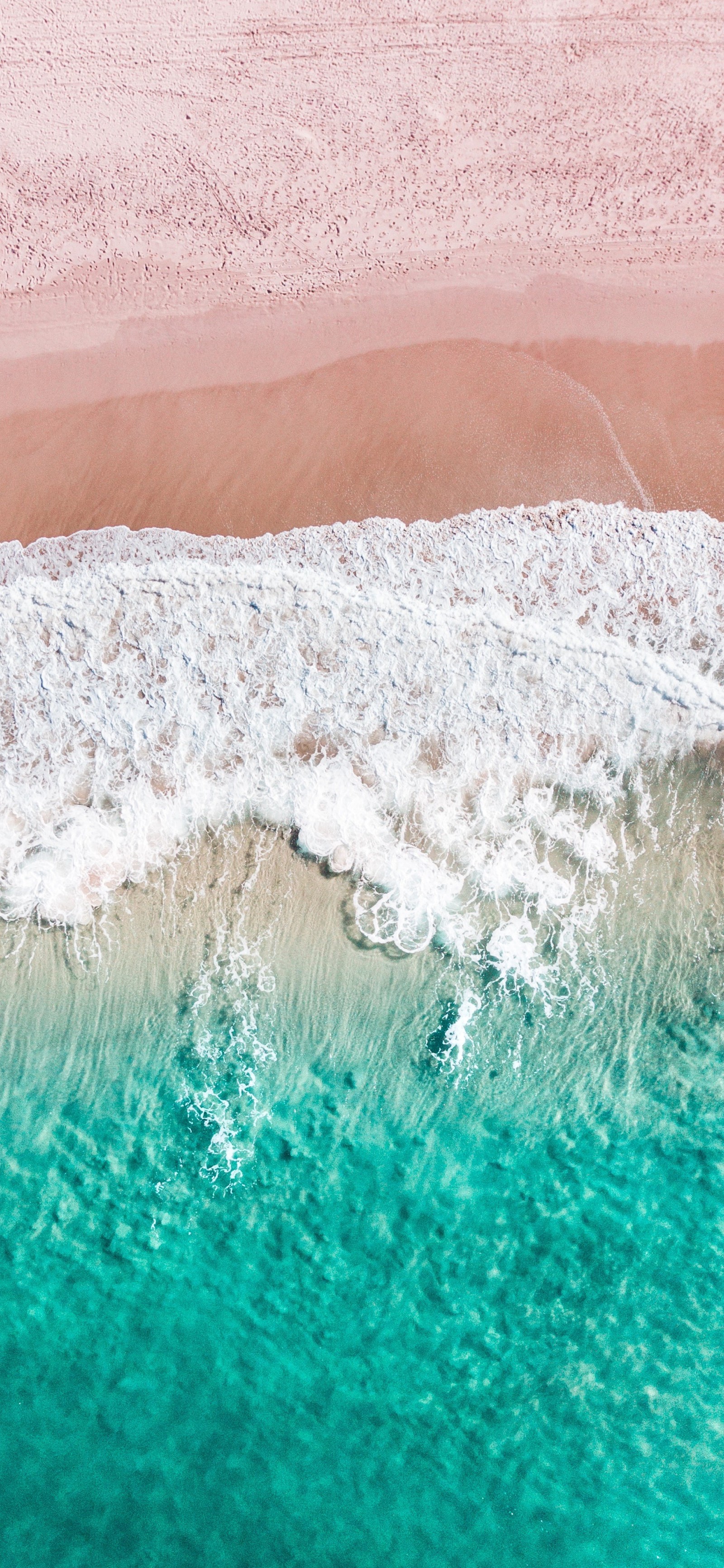 Vue aérienne d'une plage avec une planche de surf et une personne sur le rivage (eau, océan, ressources en eau, liquide, azur)