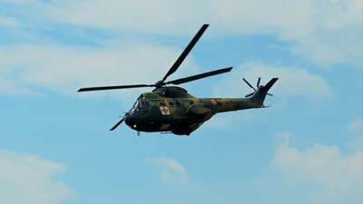 Helicóptero militar en vuelo contra un cielo azul