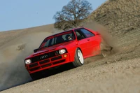 Audi Quattro coche de rally derrapando en terreno de grava