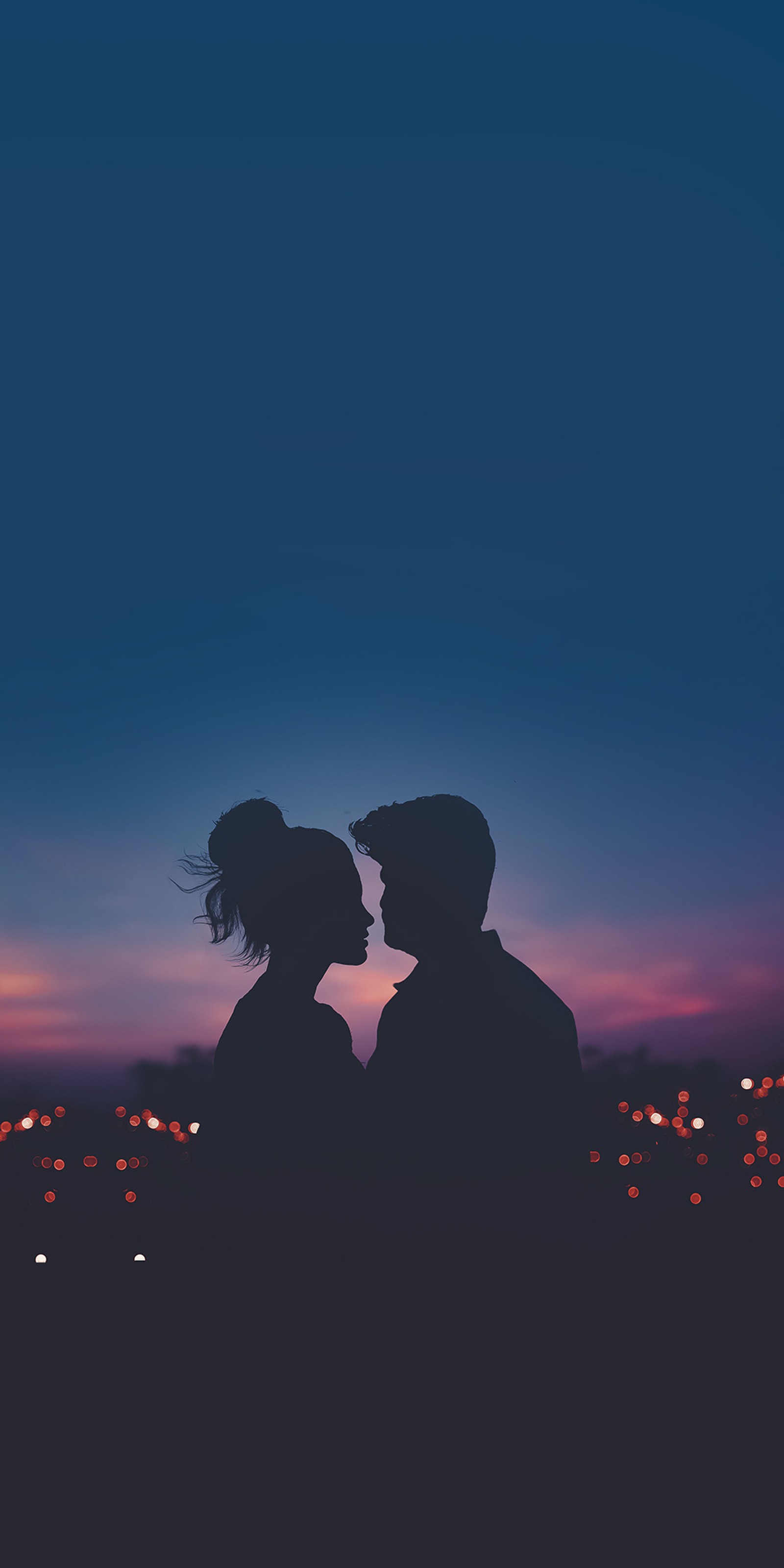 Silhouette eines paares, das sich vor einer stadt in der nacht küsst. (paar, couplegoals, dunkle liebe, liebe, love desire)