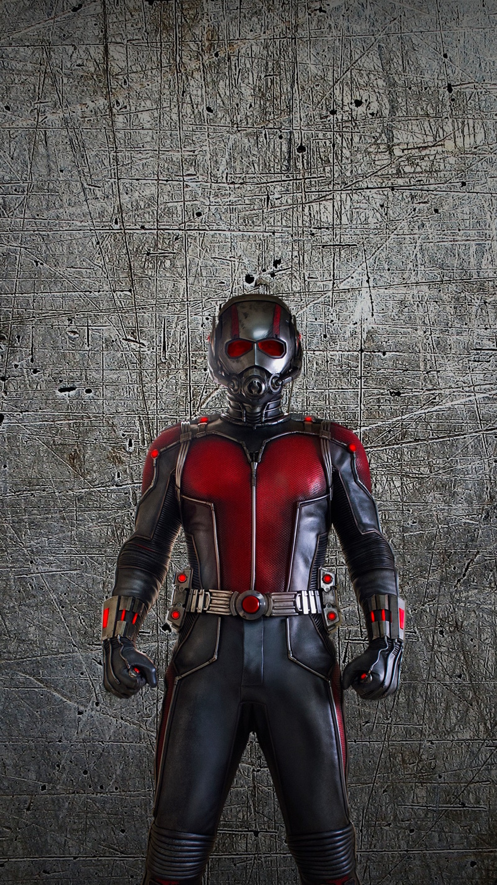 Una jirafa vestida con un traje negro y rojo de pie frente a una pared. (ant man, vengadores, avengers, marvel)