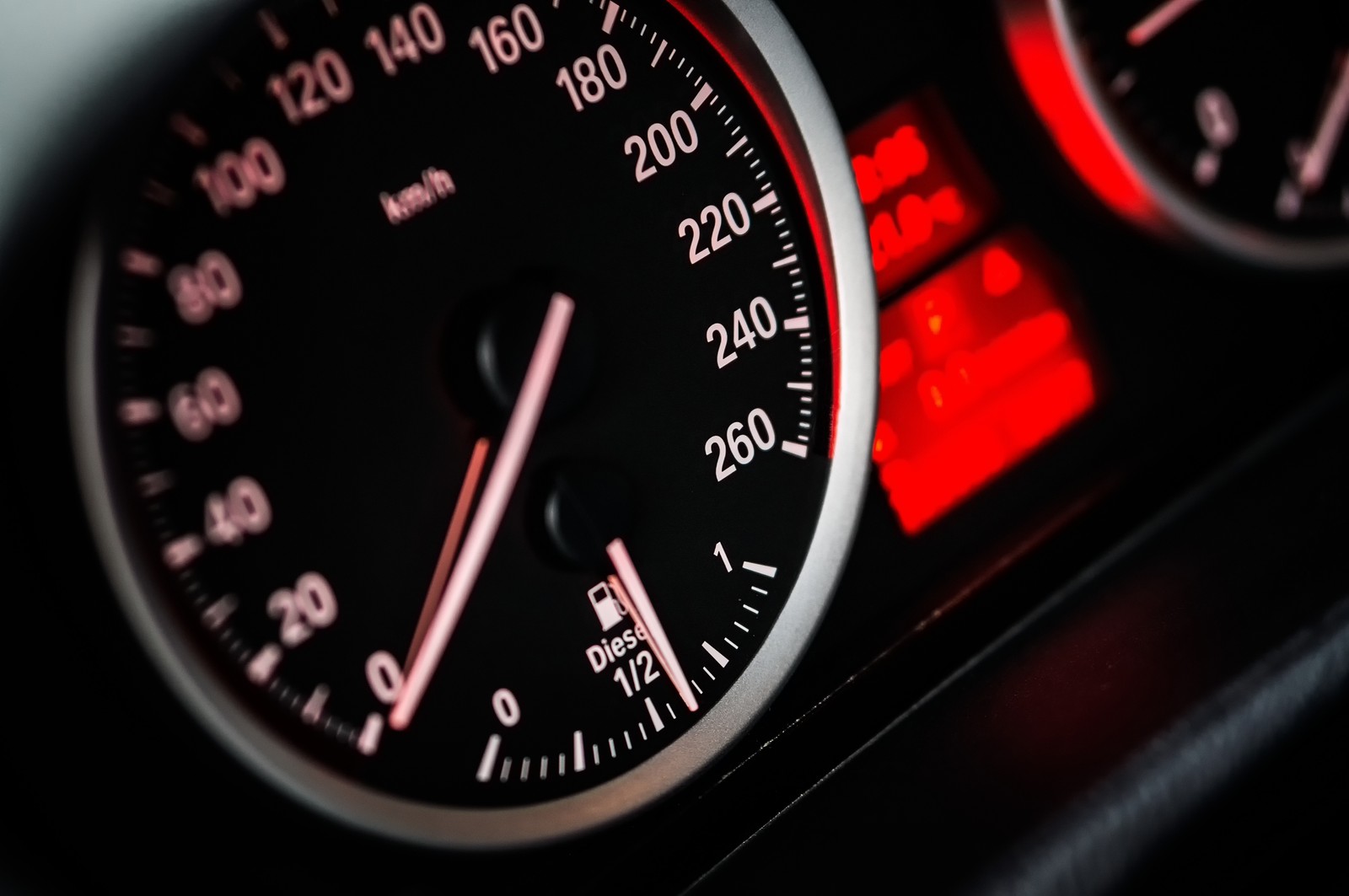 A close up of a car dashboard with a speedometer and a clock (auto, meter)