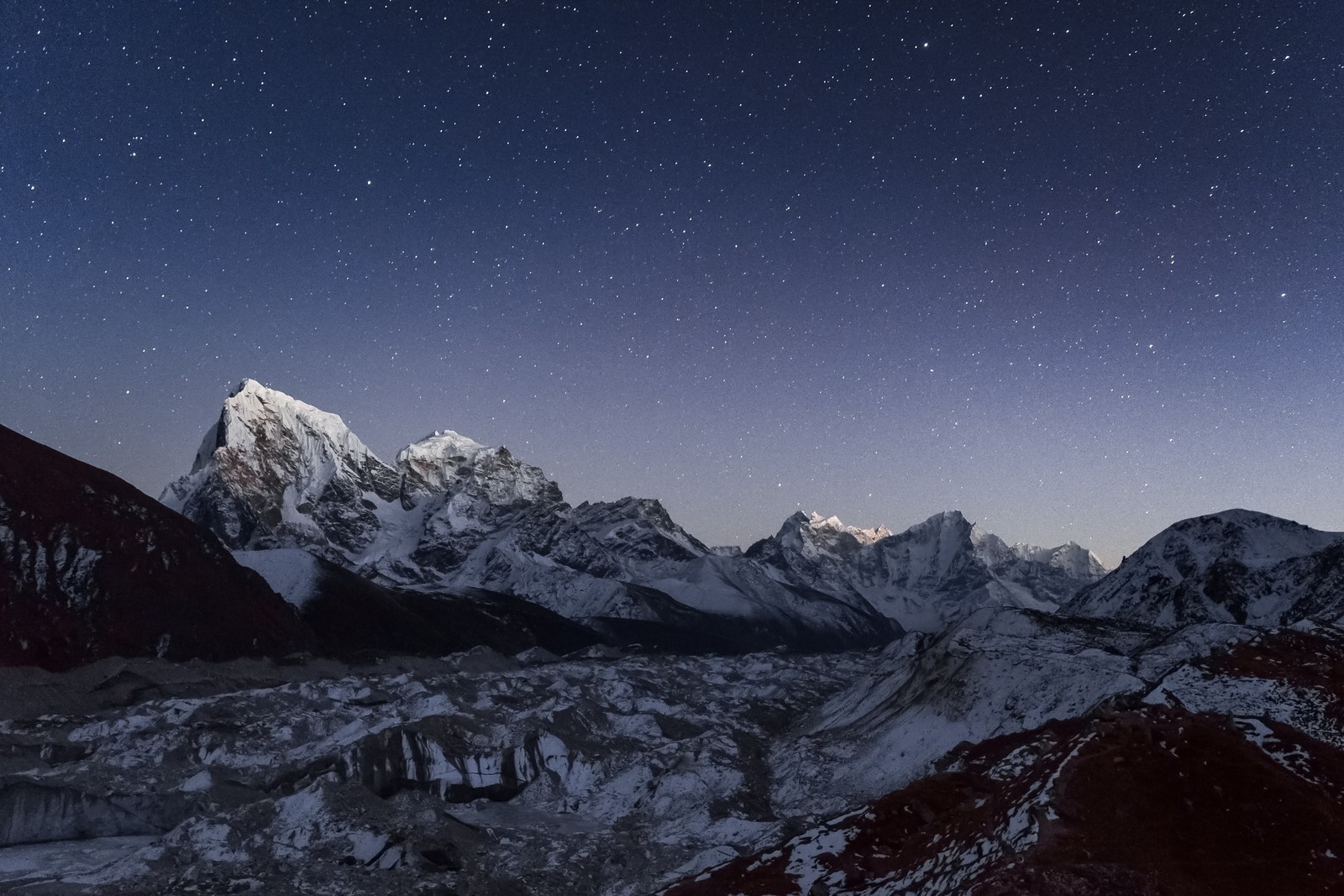 A view of a mountain range with a star filled sky (mount cholatse, ngozumpa glacier, nepal, himalayas, gokyo valley)