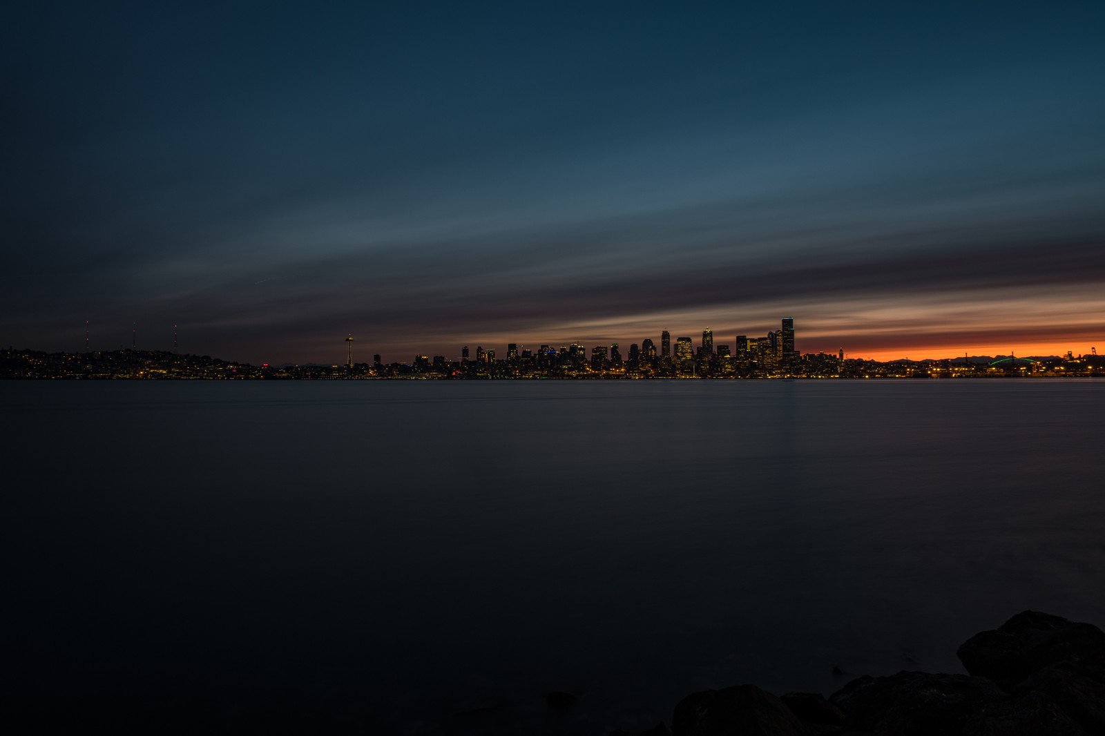 Uma vista árabe do horizonte da cidade à noite com uma longa exposição (seattle, noite, água, horizonte, anoitecer)