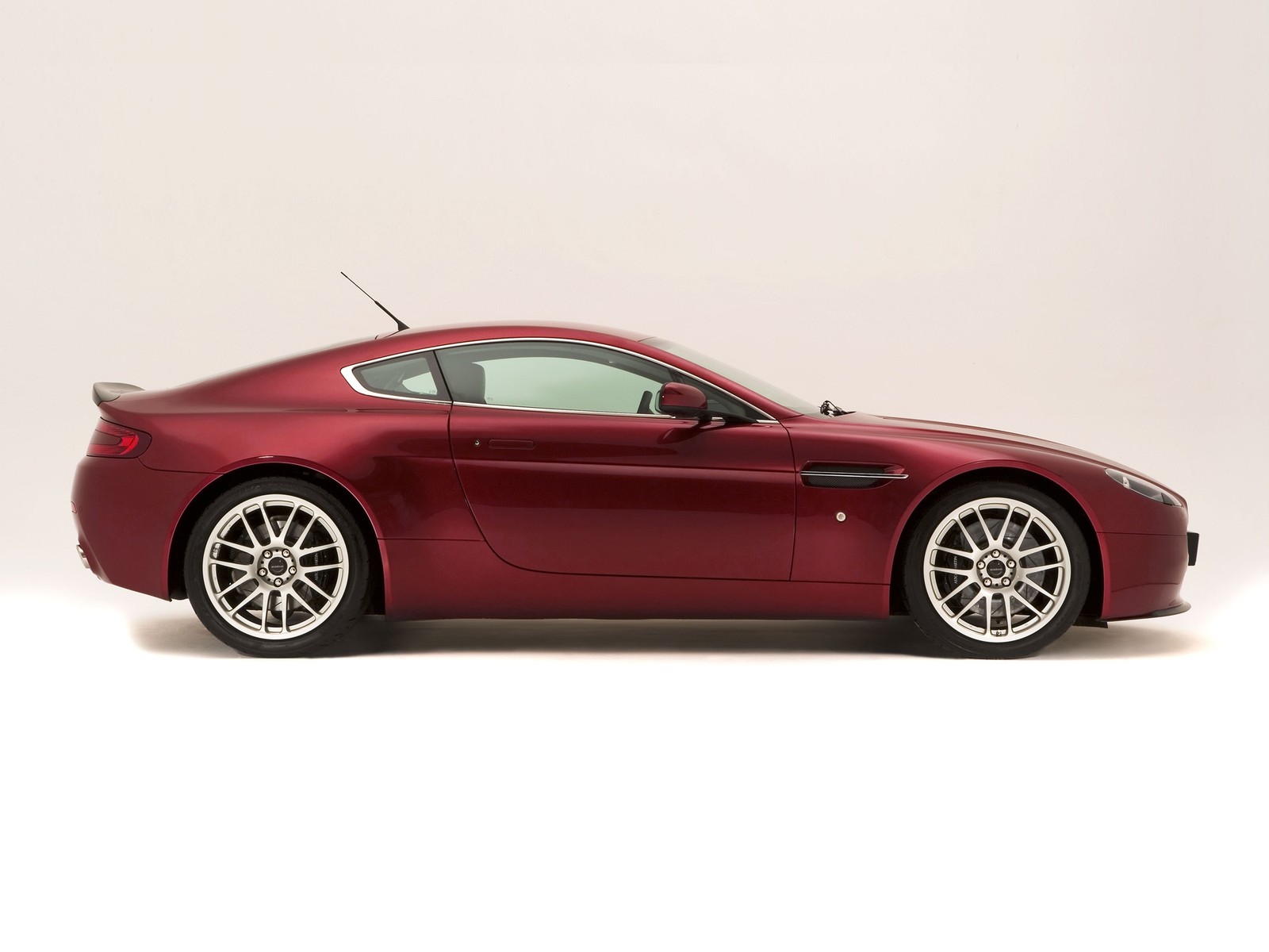 Um close de um carro esportivo vermelho em um fundo branco (aston martin vantage, aston martin dbs v12, conversível, motor v8, v8 engine)