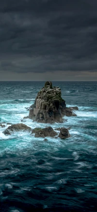 Vagues orageuses entourant un affleurement rocheux