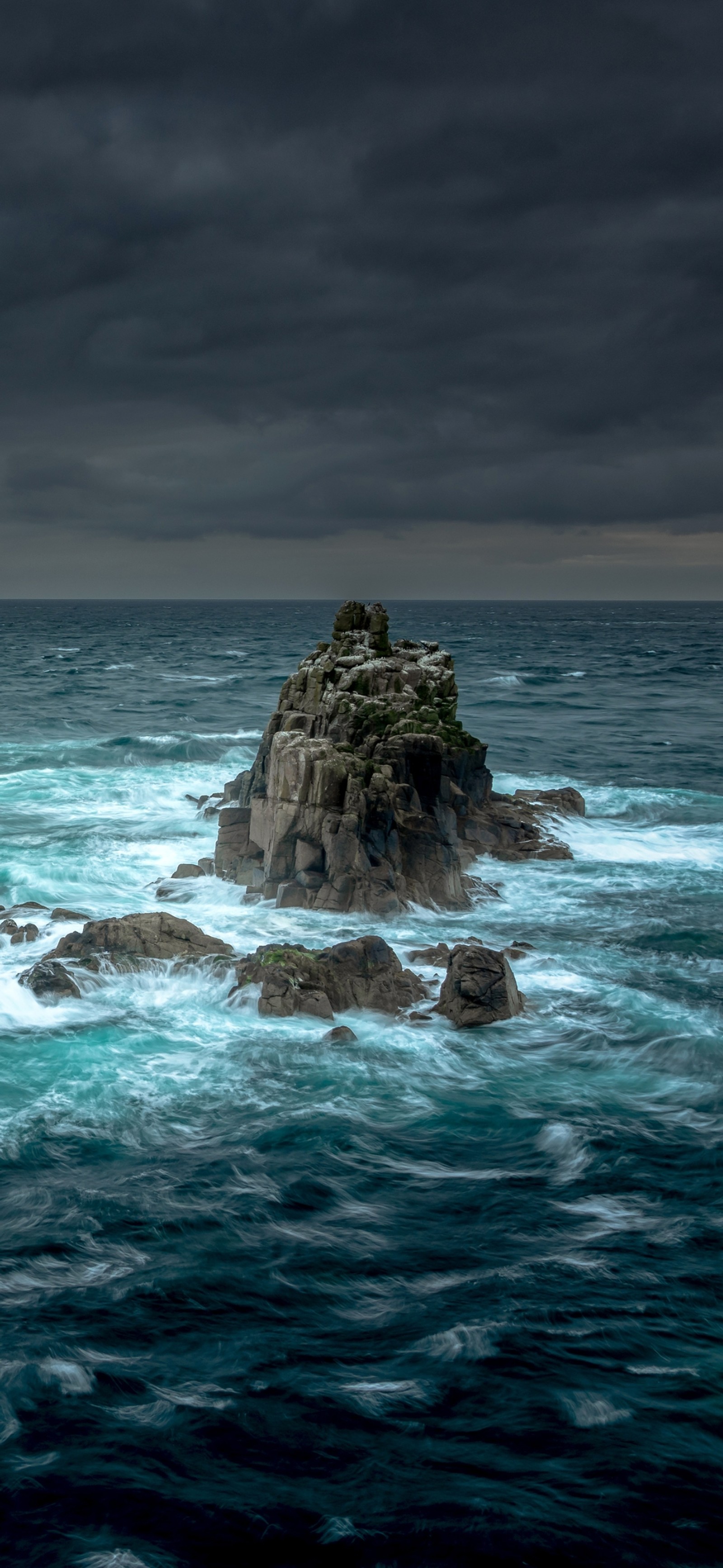 Hay una gran roca en el medio del océano. (tormenta, cuerpo de agua, fluido, agua, océano)