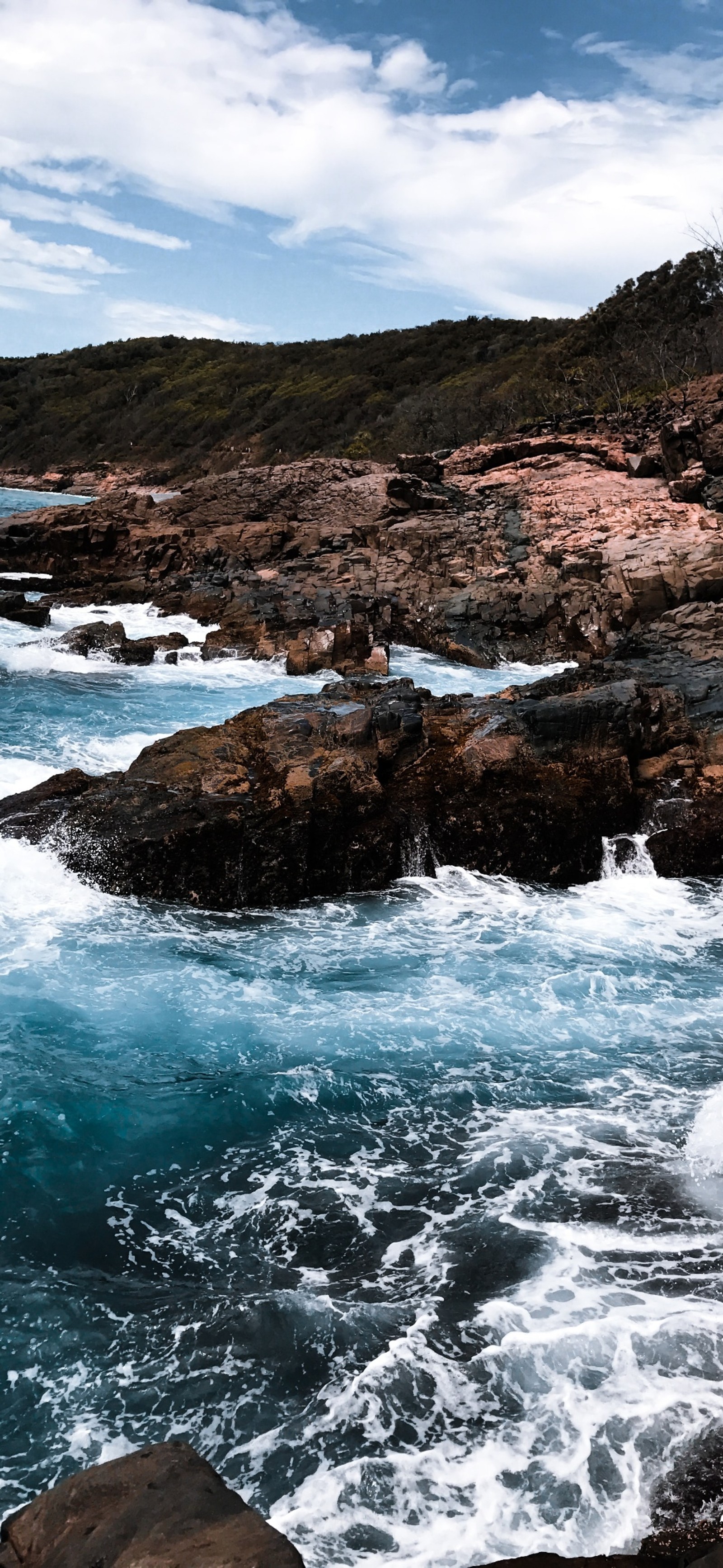 There is a man standing on a rock by the ocean (sea, coast, water, cloud, water resources)