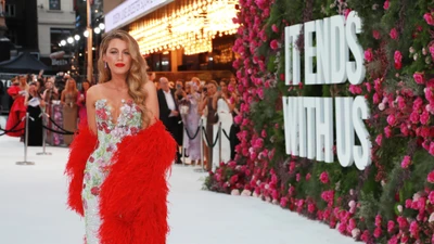 Blake Lively na estreia de "Acaba Conosco" em um deslumbrante vestido floral com um vibrante xale vermelho.