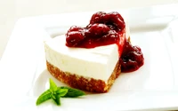 Cheesecake cremoso cubierto con salsa de cereza y menta fresca