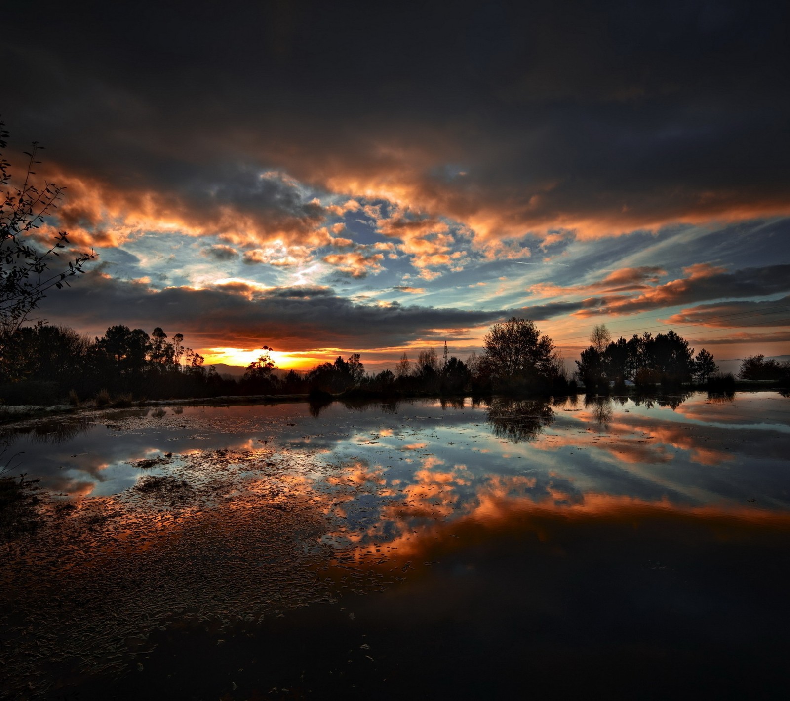 Vue d'un coucher de soleil se reflétant dans une flaque d'eau (nuage, soir, réflexion, ciel, soleil)