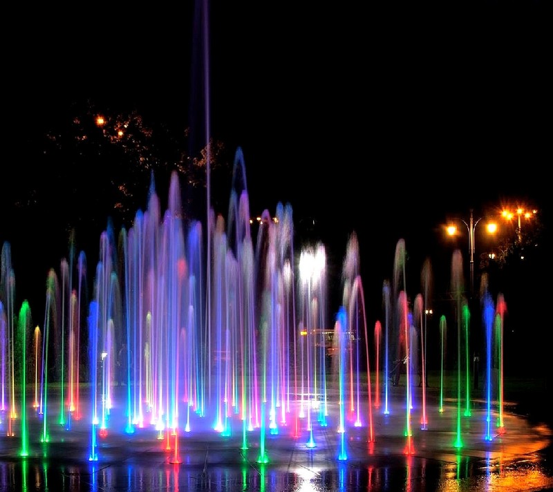 Uma fonte de luzes coloridas em um parque à noite (water fountain)