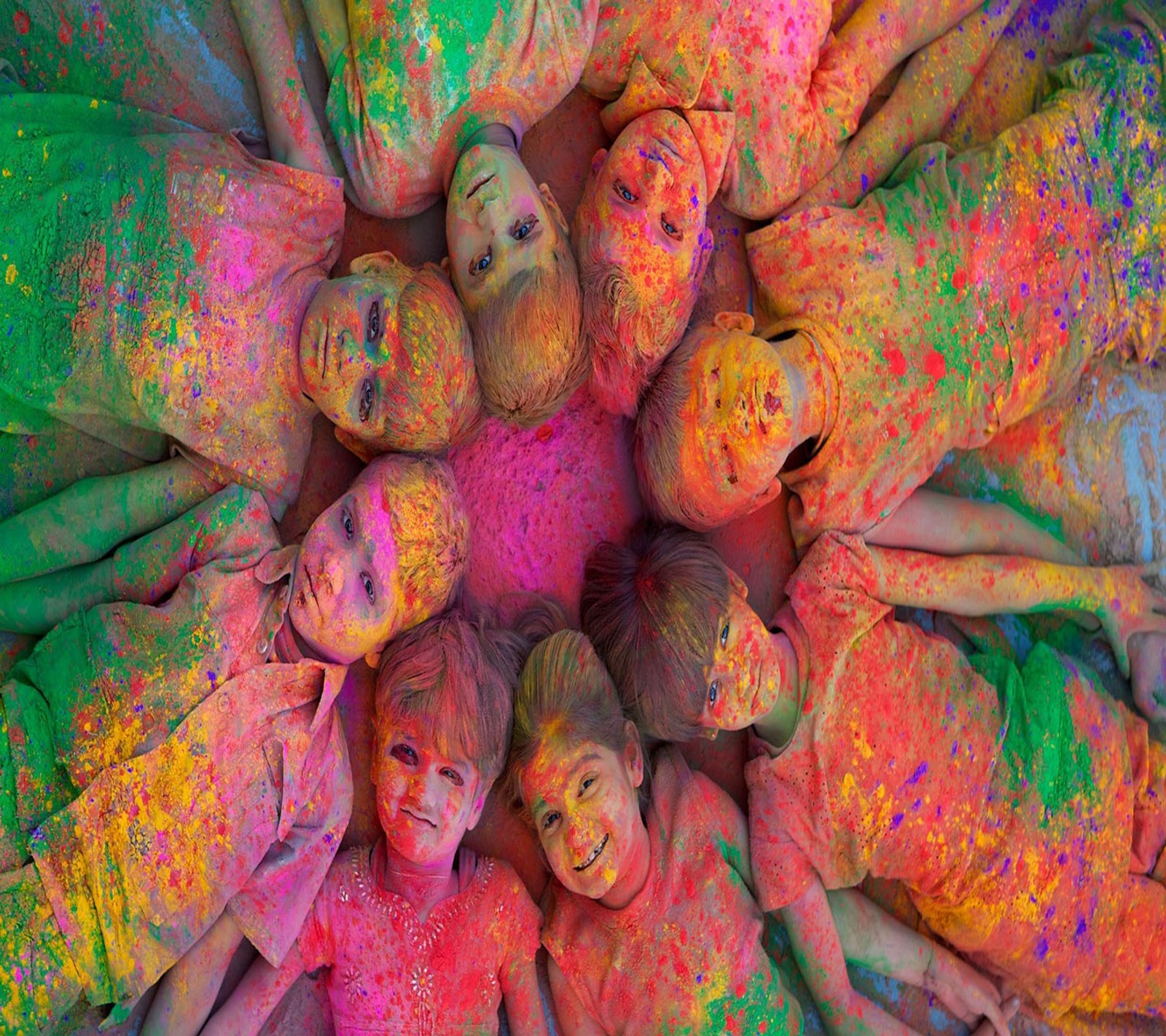 Un grupo de niños cubiertos de polvo de colores en un círculo (feliz holi, holi, holi 2013, holi colour, holi festival)