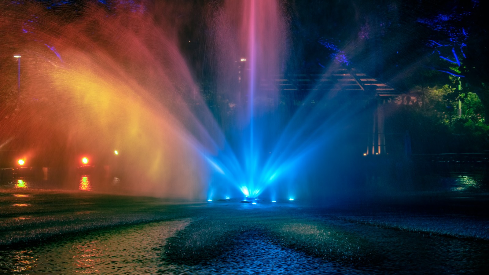 Vista de cima de uma fonte com luzes coloridas em um parque à noite (natureza, azul, verde, noite, cor)