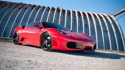 Элегантный красный Ferrari 360 Modena припаркован на фоне уникального индустриального пейзажа.