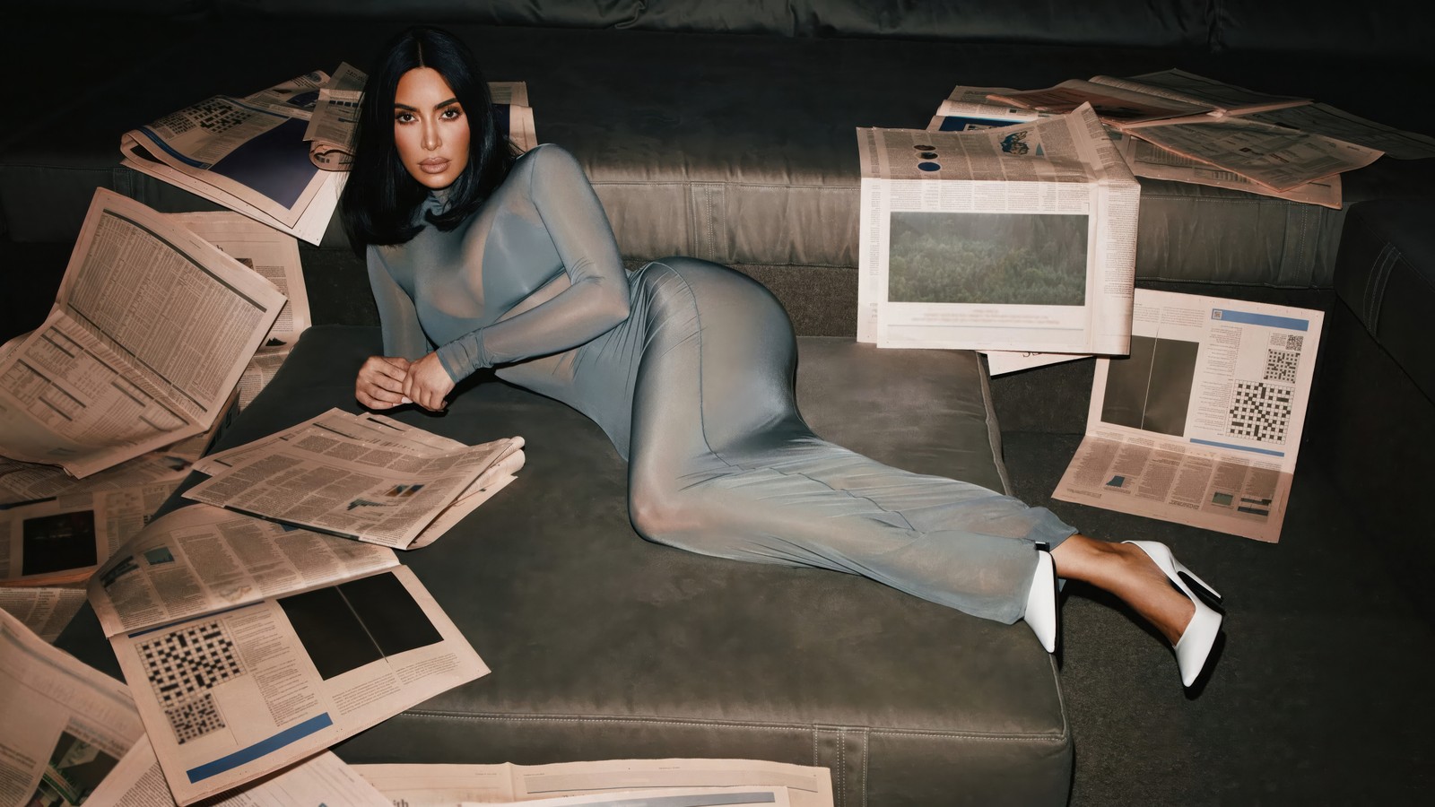 Une femme arabe en robe bleue allongée sur un canapé avec des journaux (kim kardashian, 2024, célébrités américaines, 5k, gens)