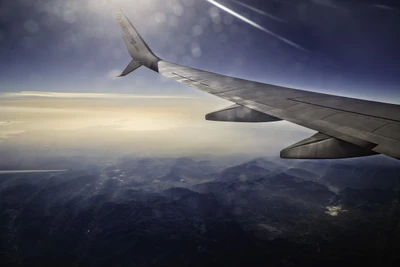 Vista serena de uma asa de avião sobre um terreno montanhoso