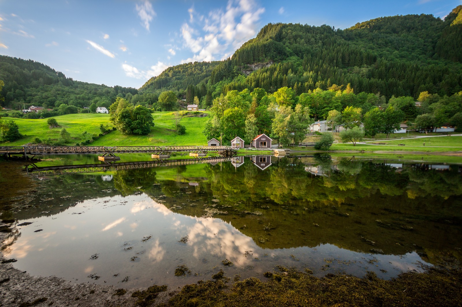 Une vue d'un petit village sur un lac avec un pont (nature, réserve naturelle, réflexion, plan deau, paysage naturel)