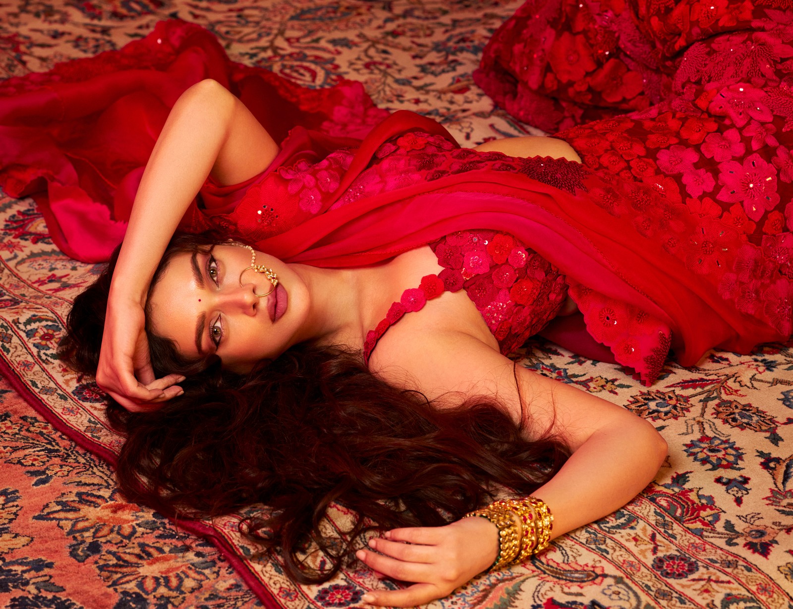 Femme arabe en robe rouge allongée sur un tapis avec les mains sur la tête (aditi rao hydari, heeramandi, esthétique rouge, actrice indienne, 5k)