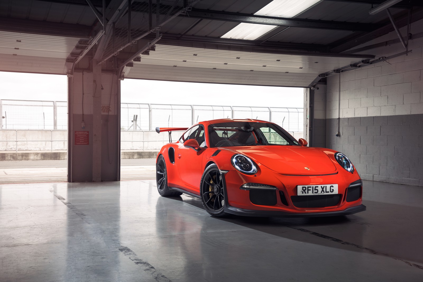 A close up of a red sports car parked in a garage (porsche, car, sports car, porsche 911 gt2, supercar)