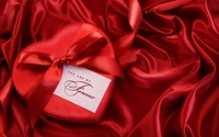 Boîte cadeau en forme de cœur romantique sur un tissu rouge luxueux