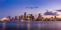 Skyline de Miami au crépuscule : Reflets urbains vibrants sur l'eau