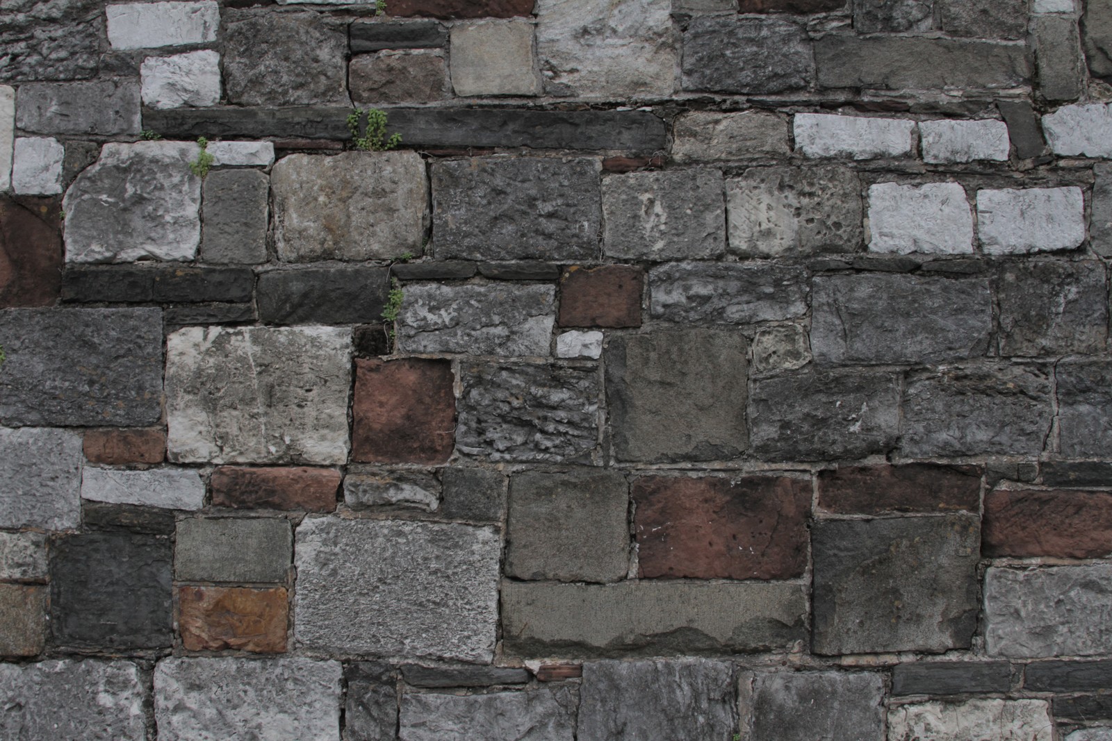 Un primer plano de una pared de ladrillos con un hidrante en el medio (pared, ladrillo, mampostería, muro de piedra, roca)