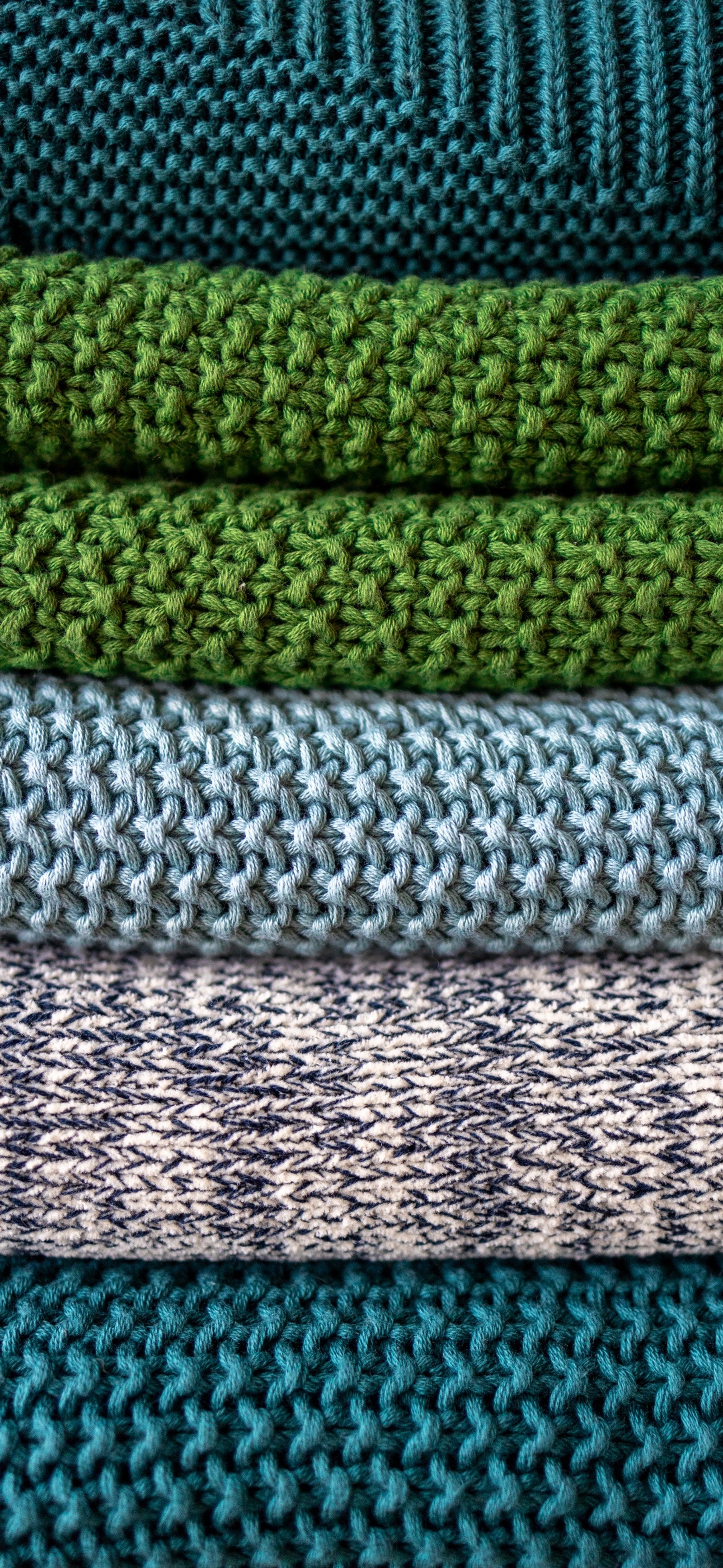 Un gros plan d'un tas de tricots de différentes couleurs (tricot, bleu, vert, azur, textile)