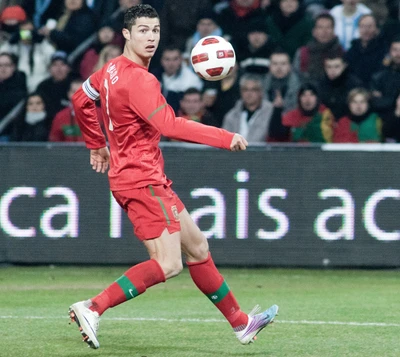 Cristiano Ronaldo em ação, controlando habilidosamente a bola durante uma partida.