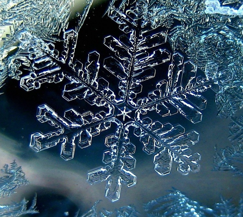 Снежинка на поверхности льда с черным фоном (лед, снежинка, зима)