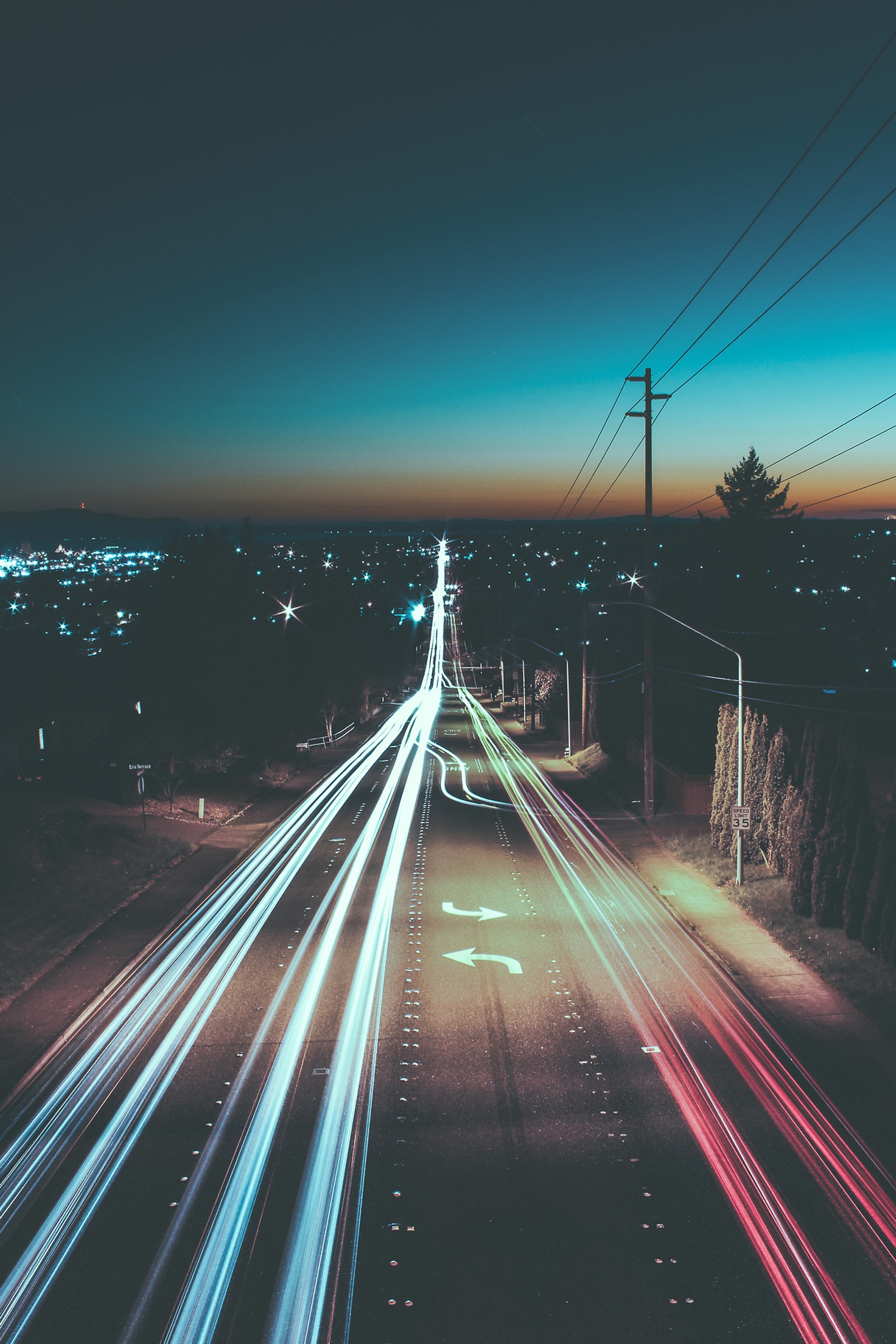 Vista aérea de una calle de la ciudad por la noche con estelas de luz (coche, ciudad, rápido, izquierda, movimiento)