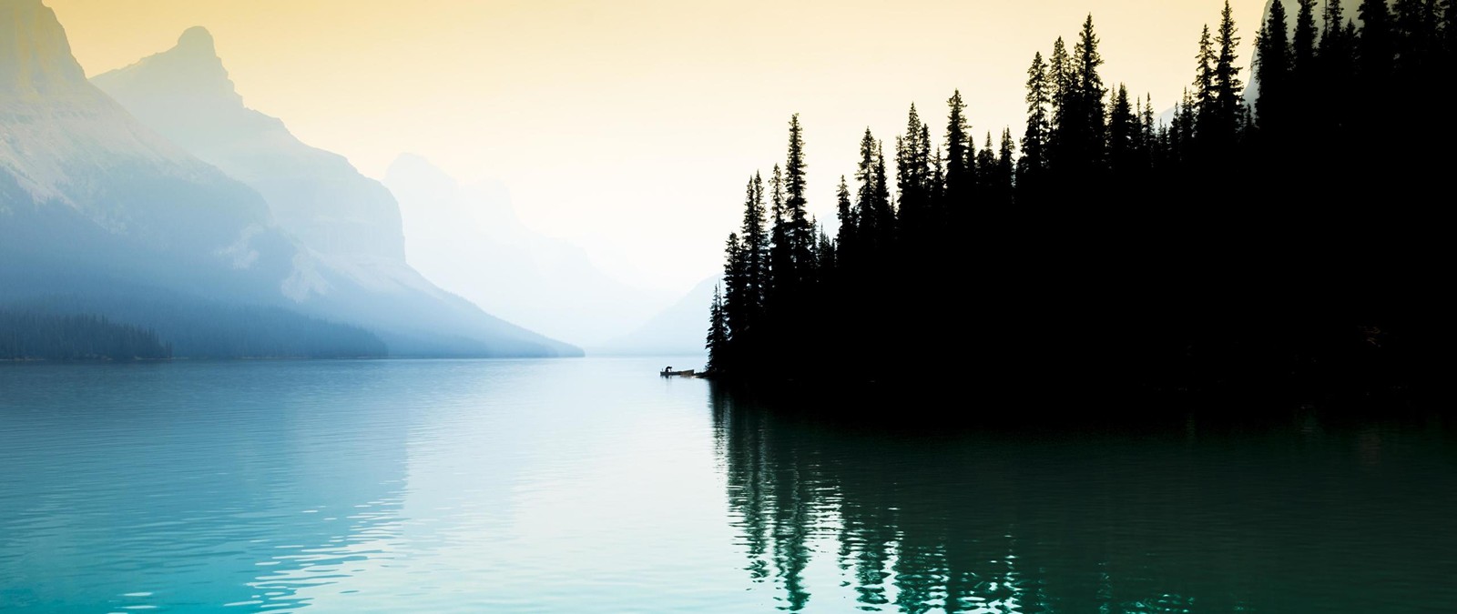 Há um barco flutuando na água perto das montanhas (corpo de água, natureza, água, reflexo, lago)