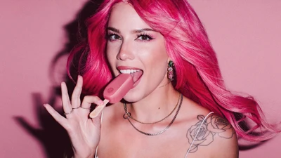 Halsey mit pinken Haaren genießt ein Eis am Stiel in einem verspielten Fotoshooting