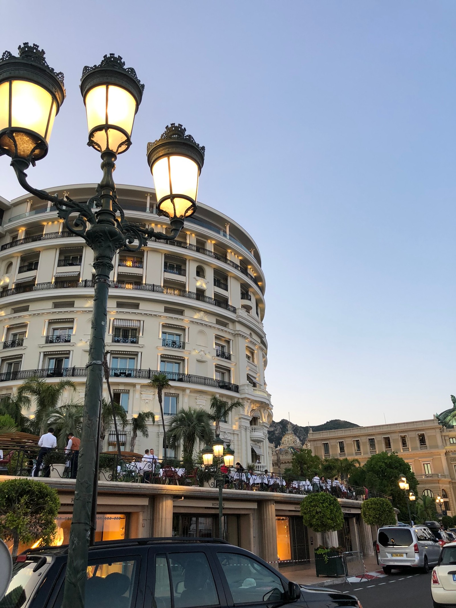 Des voitures sont garées devant un bâtiment avec un lampadaire (luminaire, réverbère, physique, science, roi)