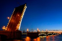 Illuminated Bridge at Night Over the Neva River in a Vibrant Metropolis