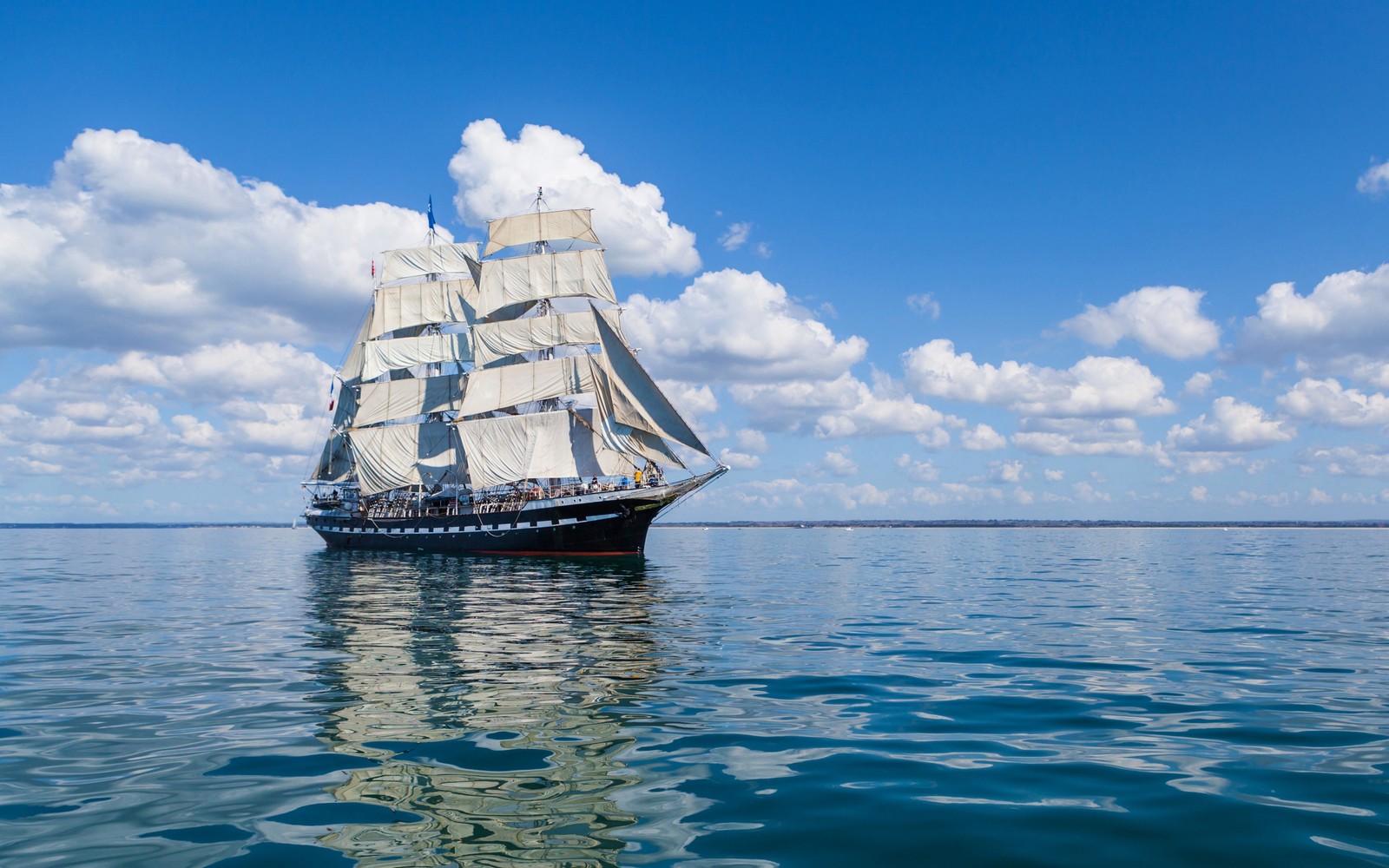 Silhouette d'un voilier dans l'océan avec des nuages en arrière-plan (navire, voilier, bateau, grand navire, voile)