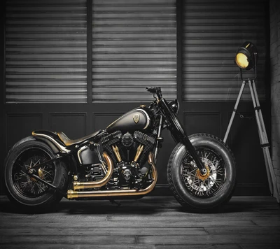 Custom Harley Davidson Softail mit einem auffälligen Schwarz-Gold-Design, das einen freiliegenden Motor und ein einzigartiges Auspuffsystem aufweist.