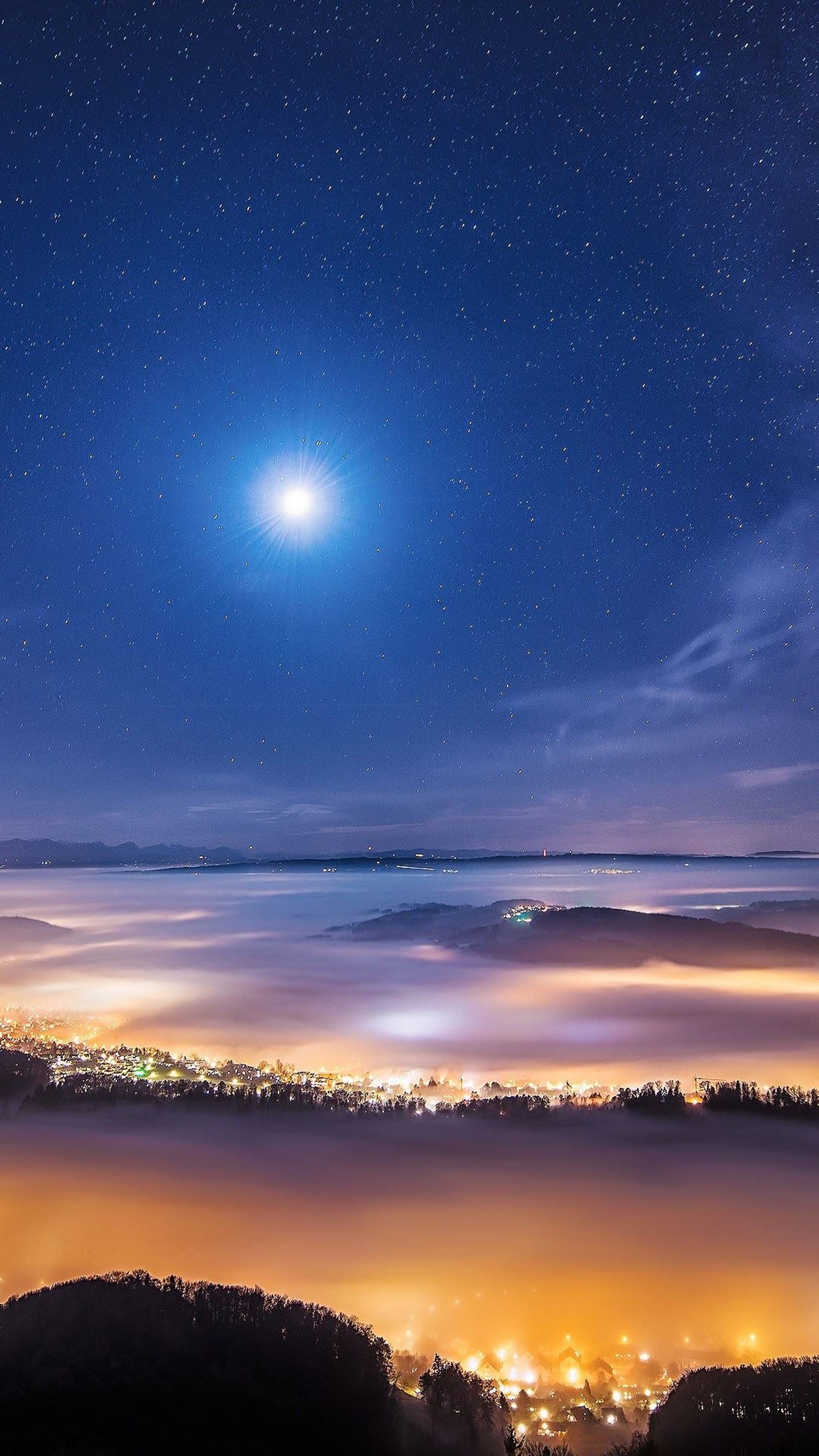 Vista noturna de uma cidade com uma lua brilhante e uma estrela brilhante (lua, noite, estrela)