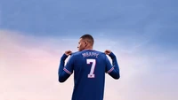 Mbappé feiert im ikonischen Trikot gegen einen bewölkten Himmel