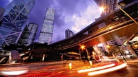 Vibrant Nighttime Cityscape with Skyscrapers and Dynamic Traffic