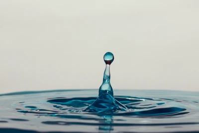 Fesselnder blauer Wassertropfen in Bewegung