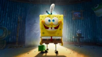 SpongeBob SquarePants se tient joyeusement dans une pièce bien éclairée, tenant une boîte-cadeau verte, incarnant le bonheur et le plaisir dans cette scène animée vibrante.