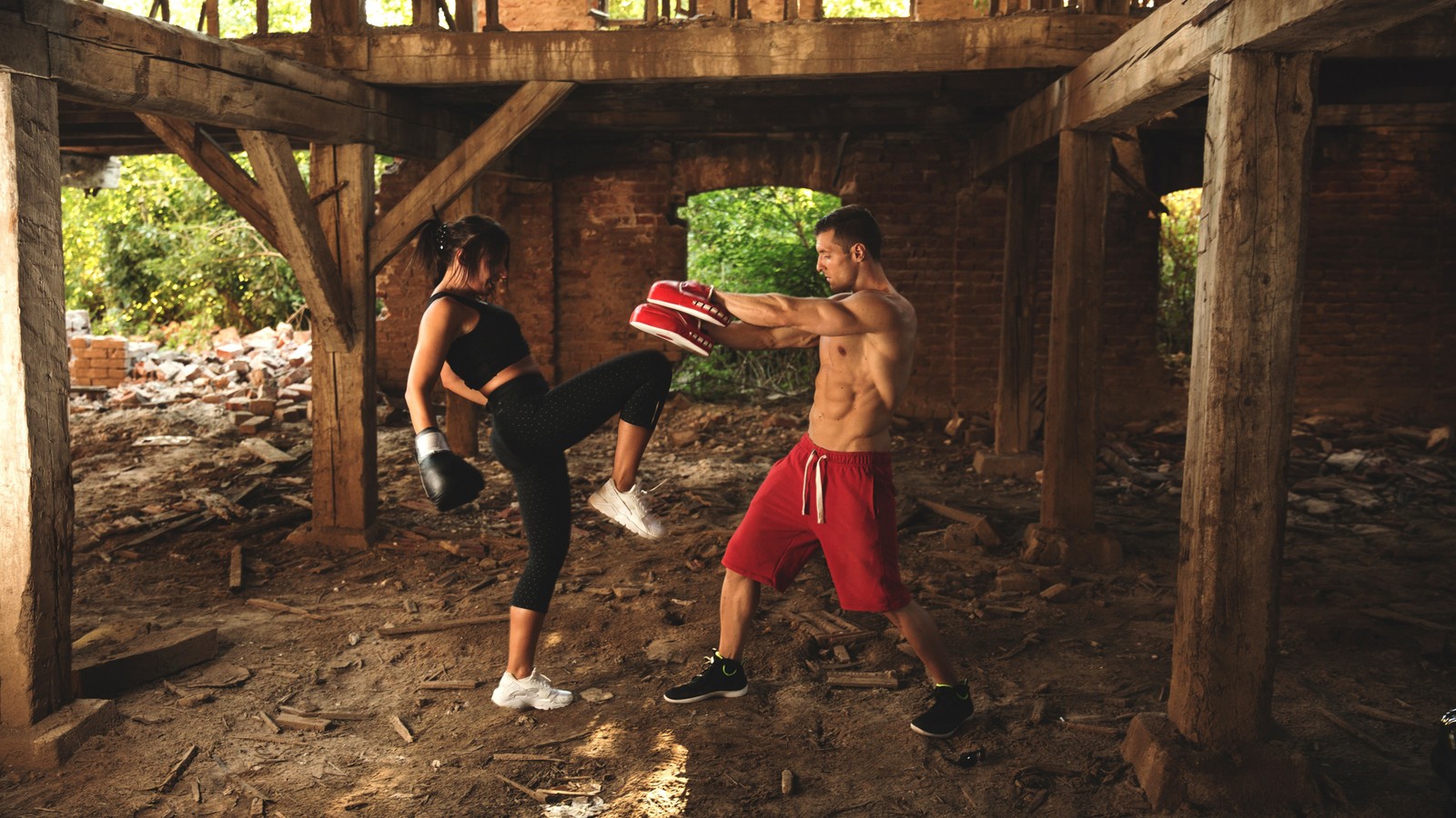 Duas pessoas estão fazendo um chute em um prédio em ruínas (boxe, kickboxing, atleta, diversão, lazer)