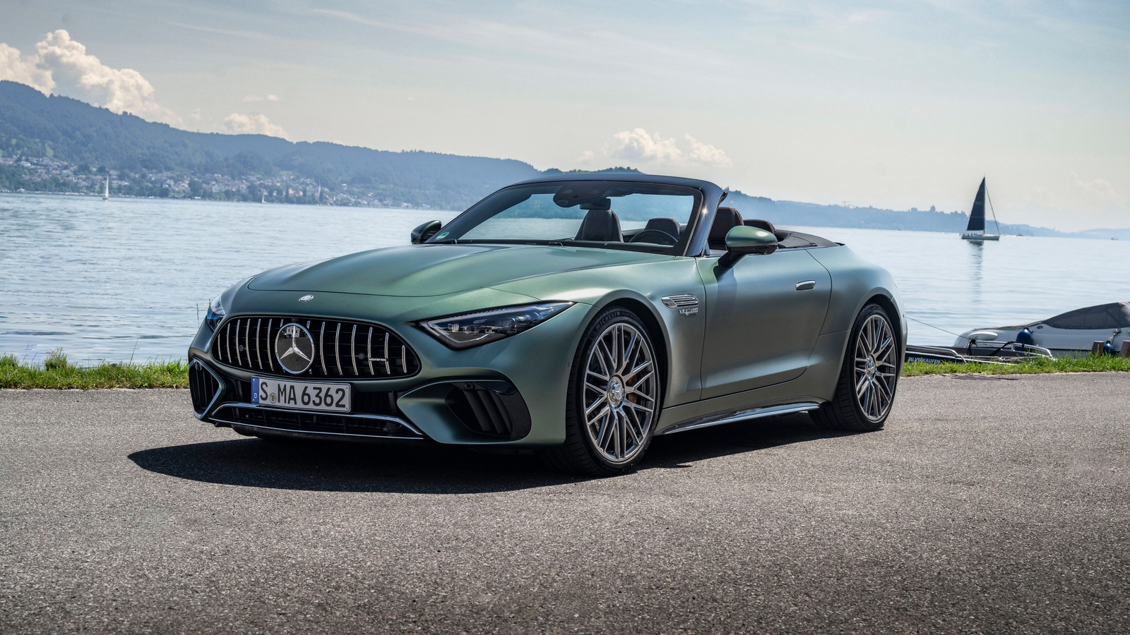 The mercedes amg gt roads roadster is parked on the road near the water (mercedes amg sl roadster, 2024, 5k, 8k, cars)