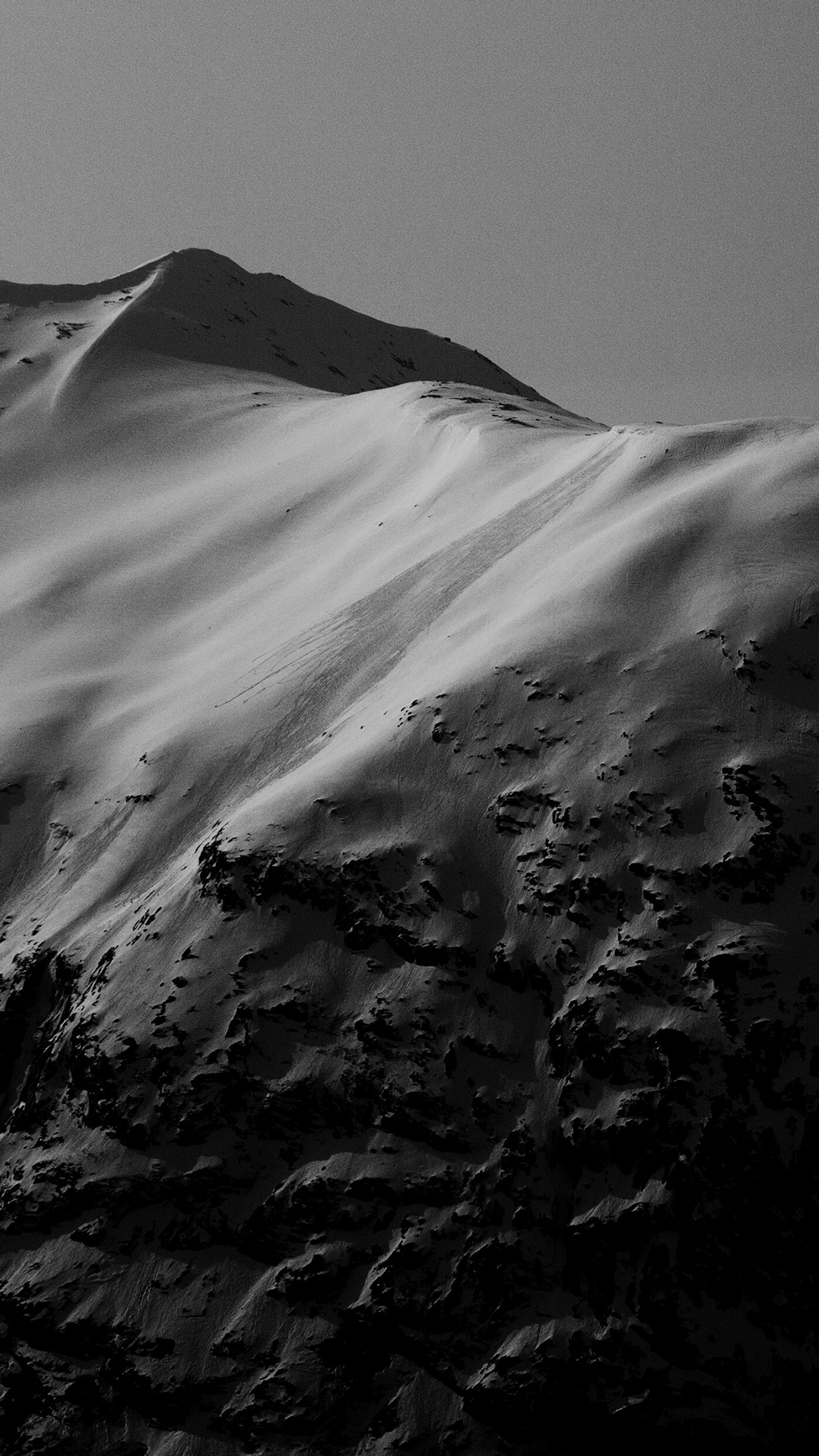 Arafed mountain with a snow covered slope and a lone person on a snowboard (black, cool, mountain, nature, norway)