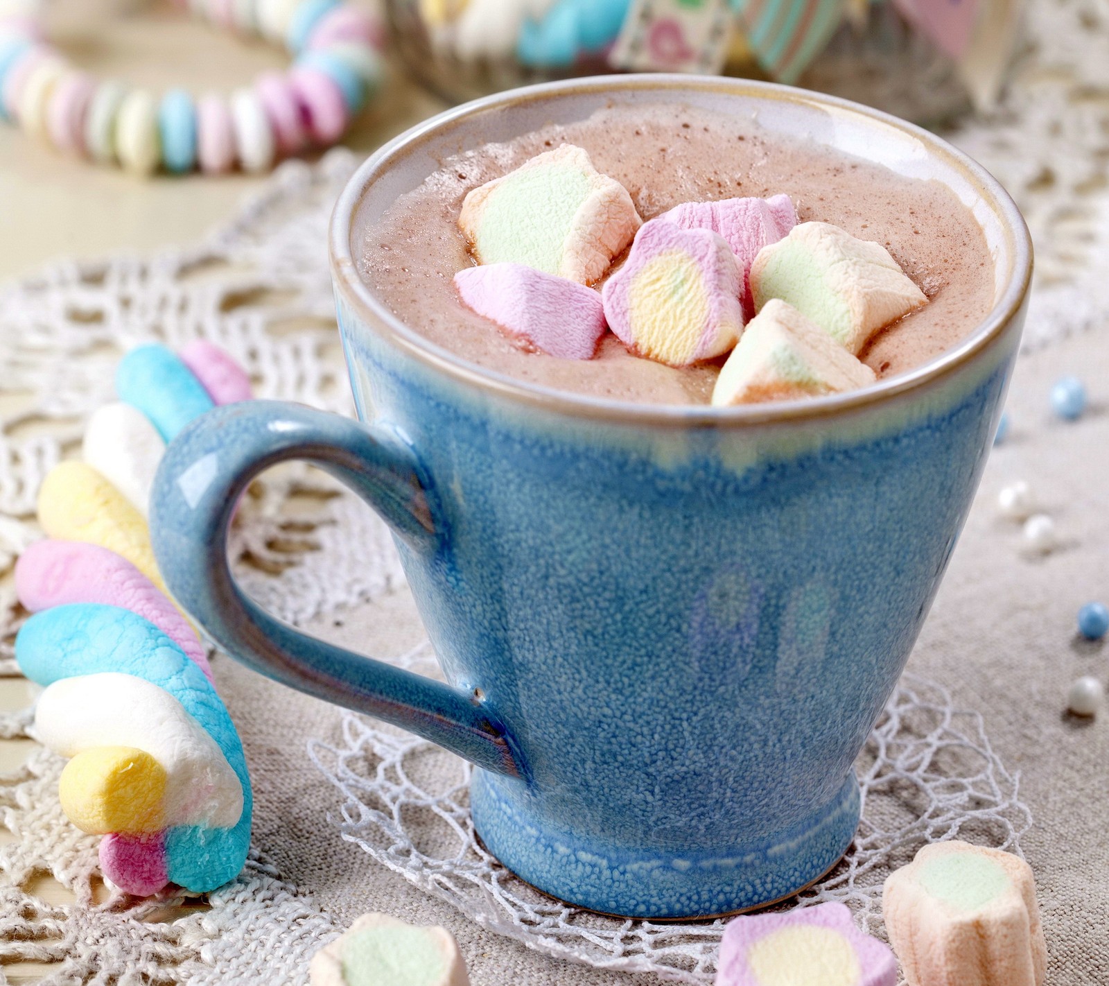 There is a cup of hot chocolate with marshmallows on the side (candy, chocolate, christmas, merry, sweet)