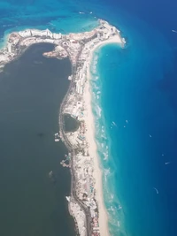 Aerial view of a vibrant beach coastline with turquoise ocean waters and sandy shores.