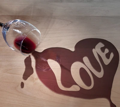 Verschütteter Wein, der ein Herz mit dem Wort "Liebe" bildet