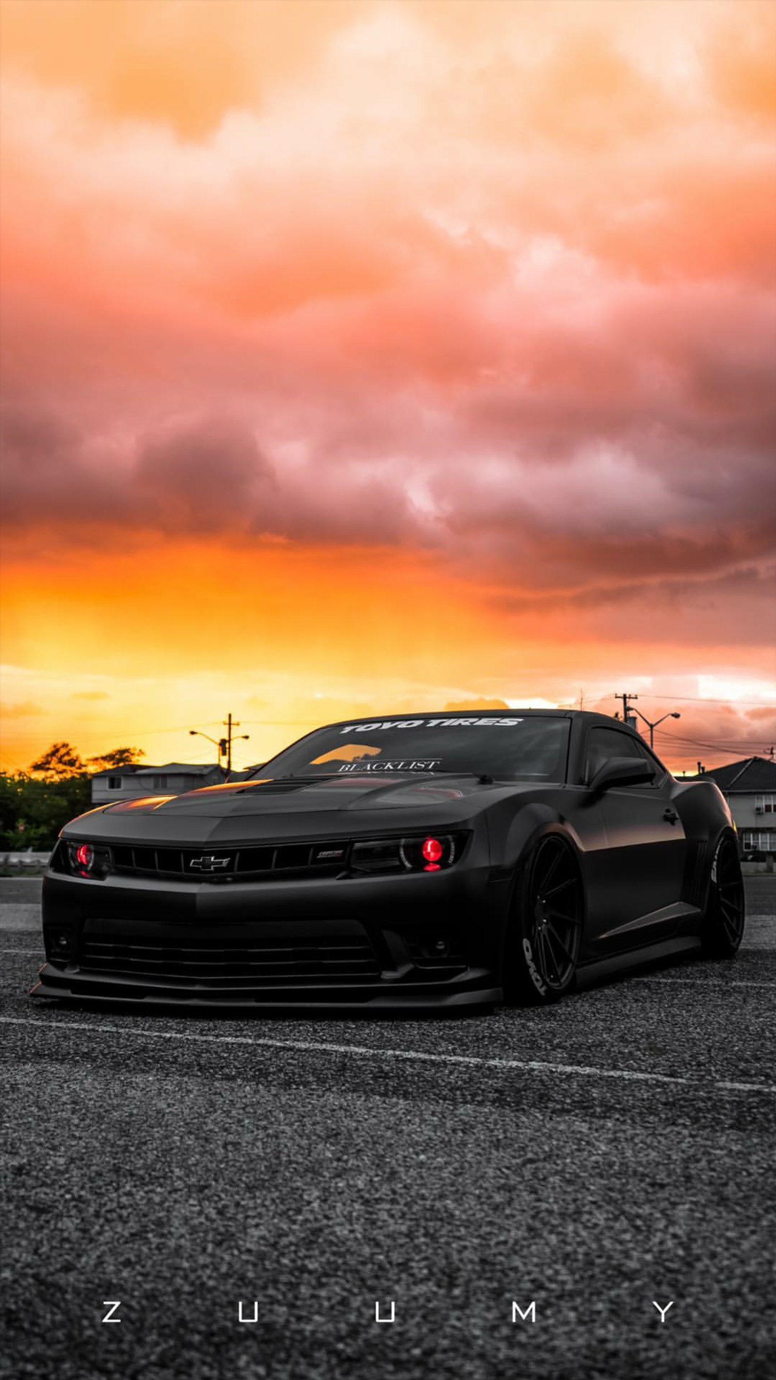 Imagen editada de un coche deportivo negro estacionado en un aparcamiento (chevrolet, camaro, negro, rojo, coche)