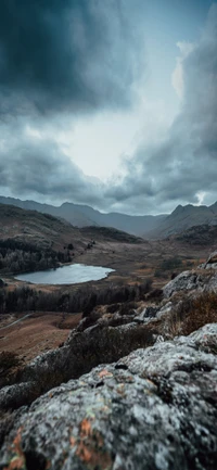 Paisaje tranquilo de las tierras altas con montañas y lago bajo cielos nublados